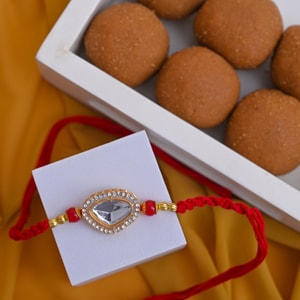 Teardrop Mirror Rakhi with Besan Laddu Hamper