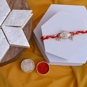 Divine Pearl Om Rakhi with Kaju Katli Hamper