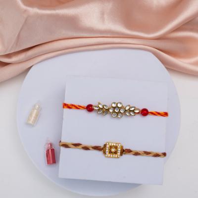 Dazzling Duo: Stone & American Diamond Rakhi Set with Besan Laddu